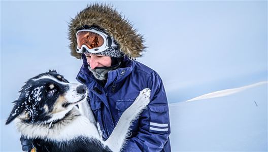 En person som koser seg med en hund