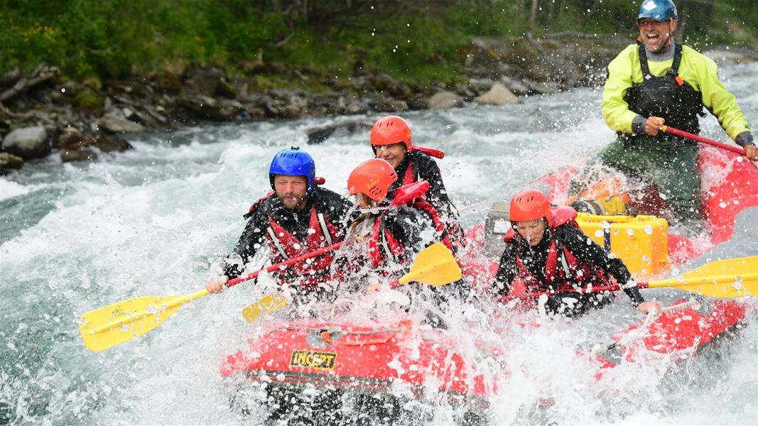 Rafting boat with participants in whitewater rapids.