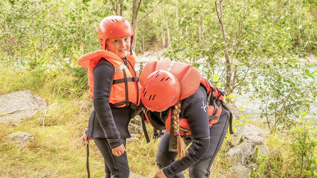 Participants with rafting gear by the riverside.