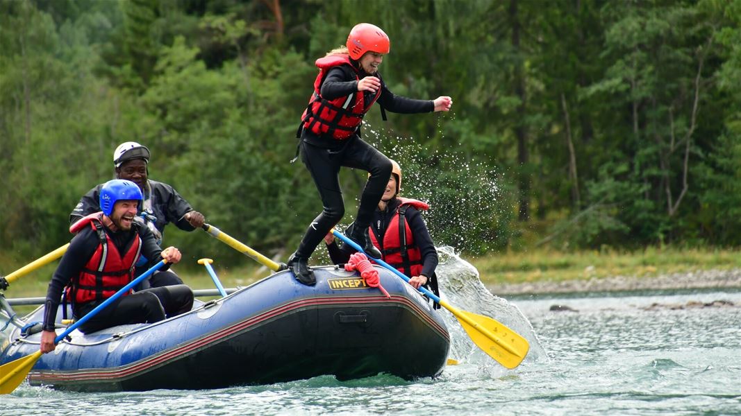 Rafting group practicing balance in the raft on the river.