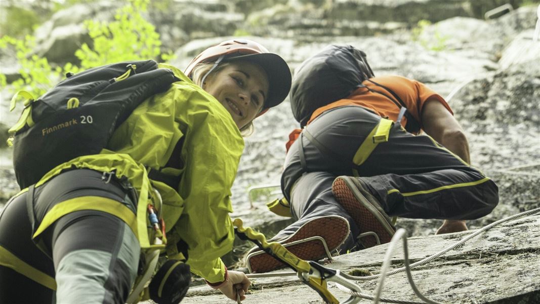 Two people climbing a secured rock route.