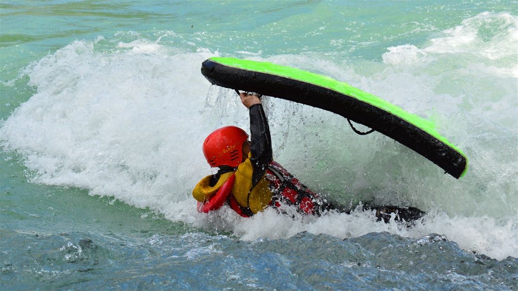 Person kayaking through a wave.