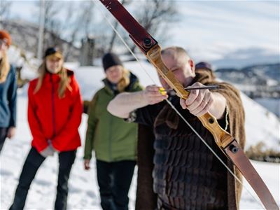 Guest trying archery as part of the Viking-inspired activities during a visit to the village near Tromsø.