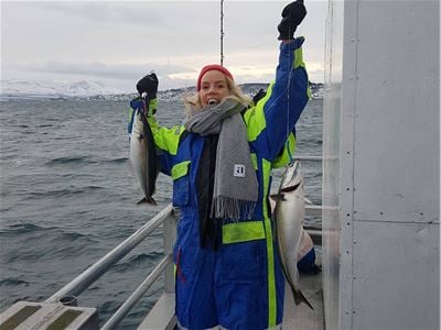 Guest showing their catch during a sea fishing experience with Sørøya Havfiske.