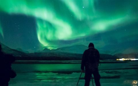 Northern Lights over the mountain landscape during a guided Northern Lights chase from Tromsø in Northern Norway.