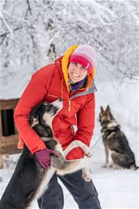 Gjest blir kjent med en av huskyene på den familiedrevne huskyfarmen i Målselv.