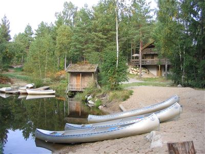 Kanoter redo för vattenläge. Bastu och Receptionen i bakgrunden