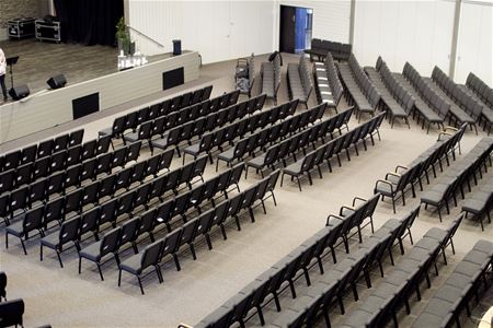 Möblerat för konferens, utställda svarta stolar i olika sektioner.