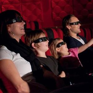Family with two children sitting in the cinema with 3d glasses on. 