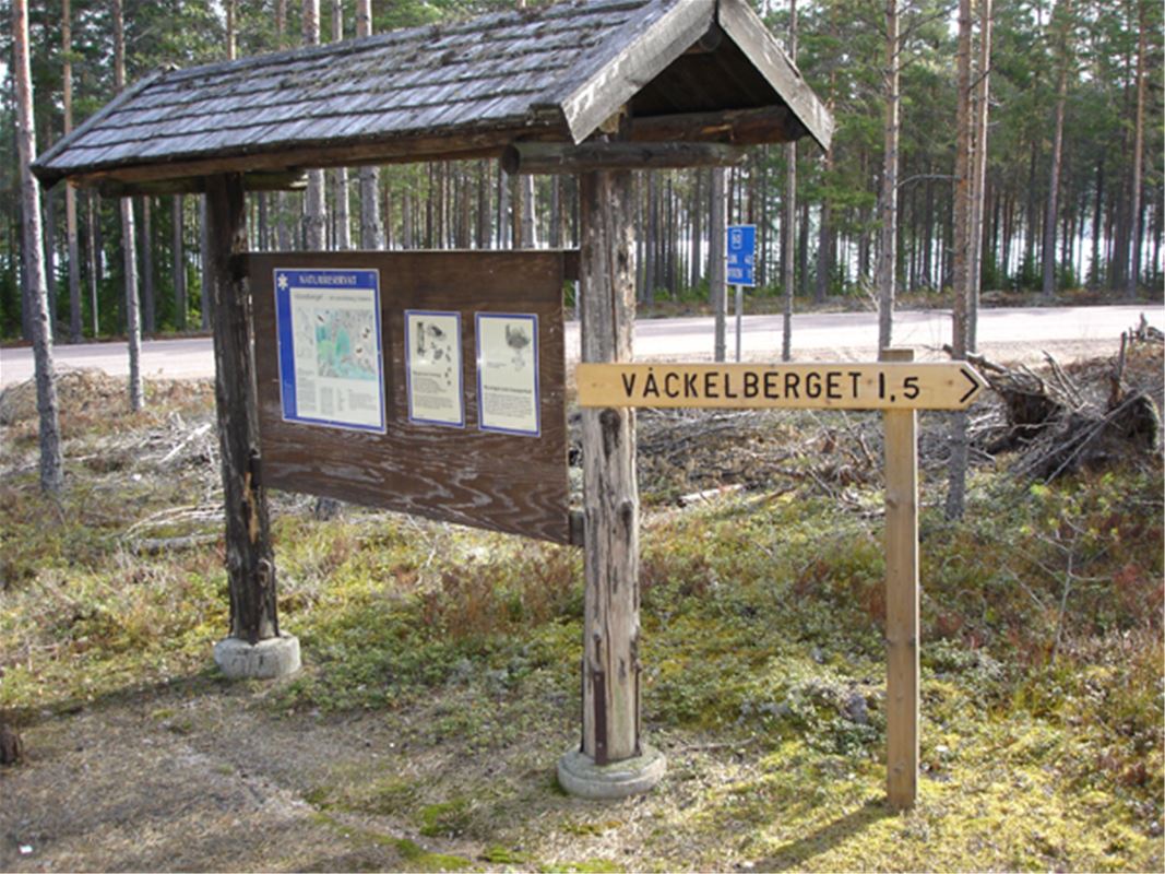 Informationstavla, träskylt med texten Våckelberget.