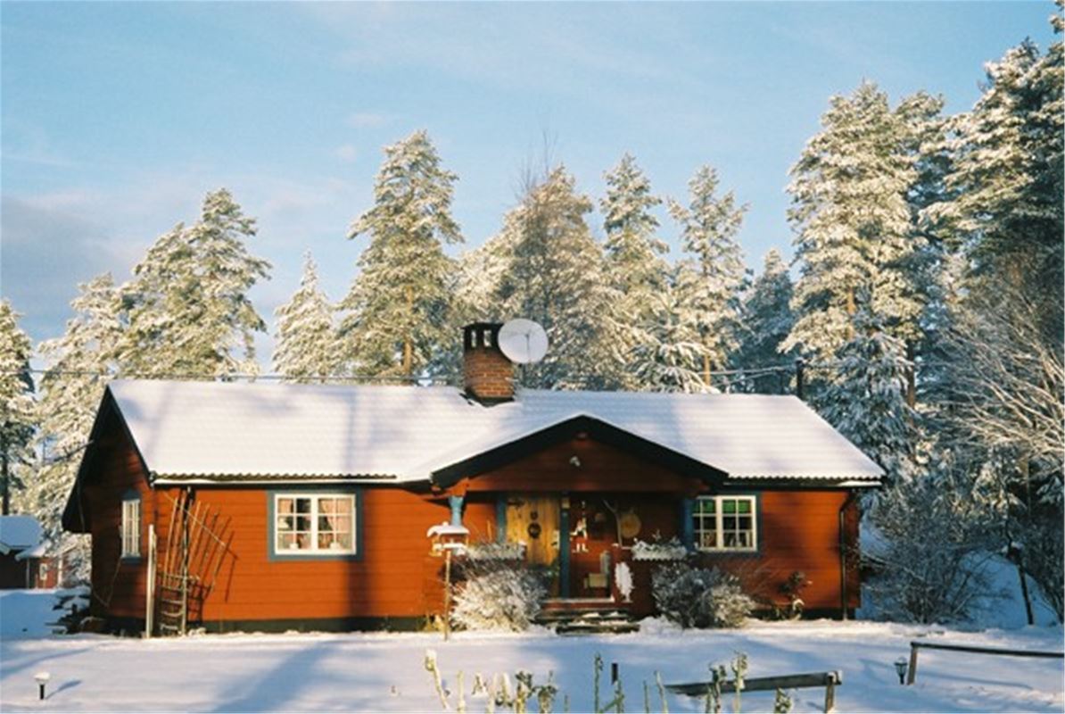 Red log cabin on a winter day.