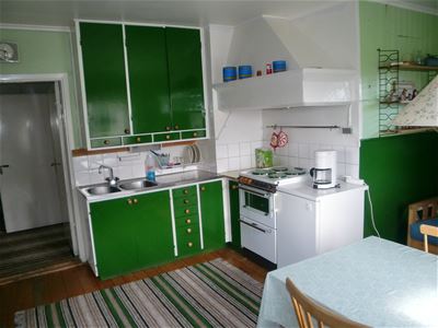 Kitchen with green cupboards. 