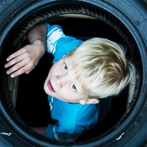 A boy looking out of a pipe.