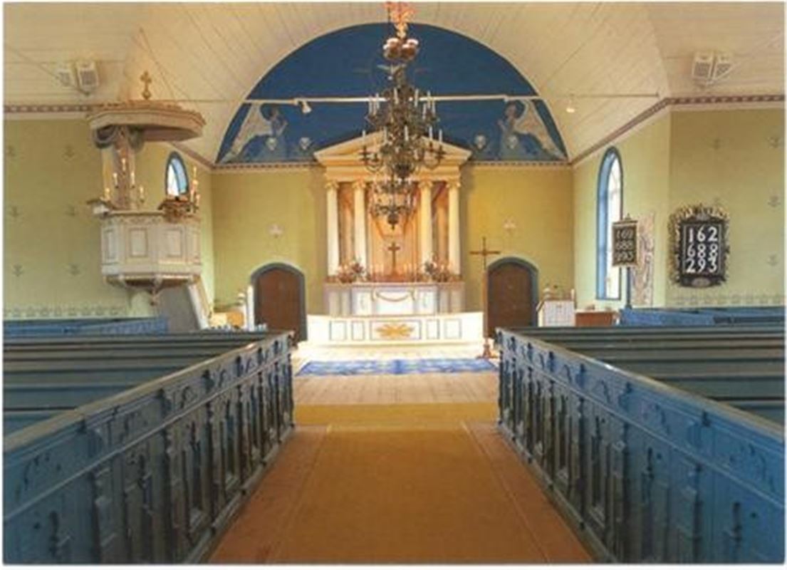 Interiörbild blå kyrkbänkar, ljusa väggar och tak, blå målning ovanför altaret.