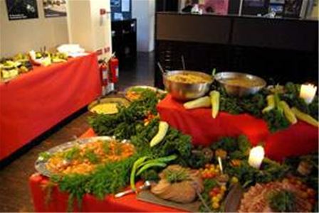 A served buffet on a table with red tablecloths.