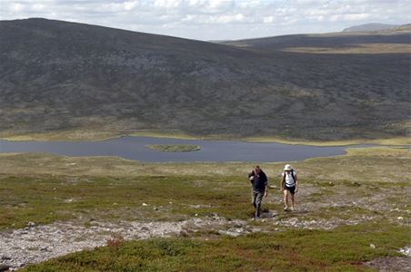 Två vandrare på leden, sjö och berg i fjärran.