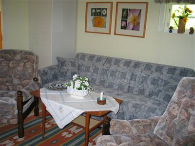 Living room, sofa, two arm chairs and a table.