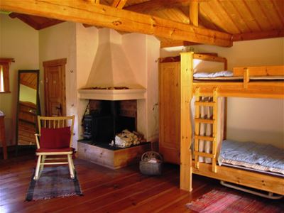 Open fireplace with rocking chair beside and a bunkbed. 