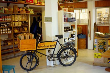 The store room with a bicycle in the middle, shelves with goods.