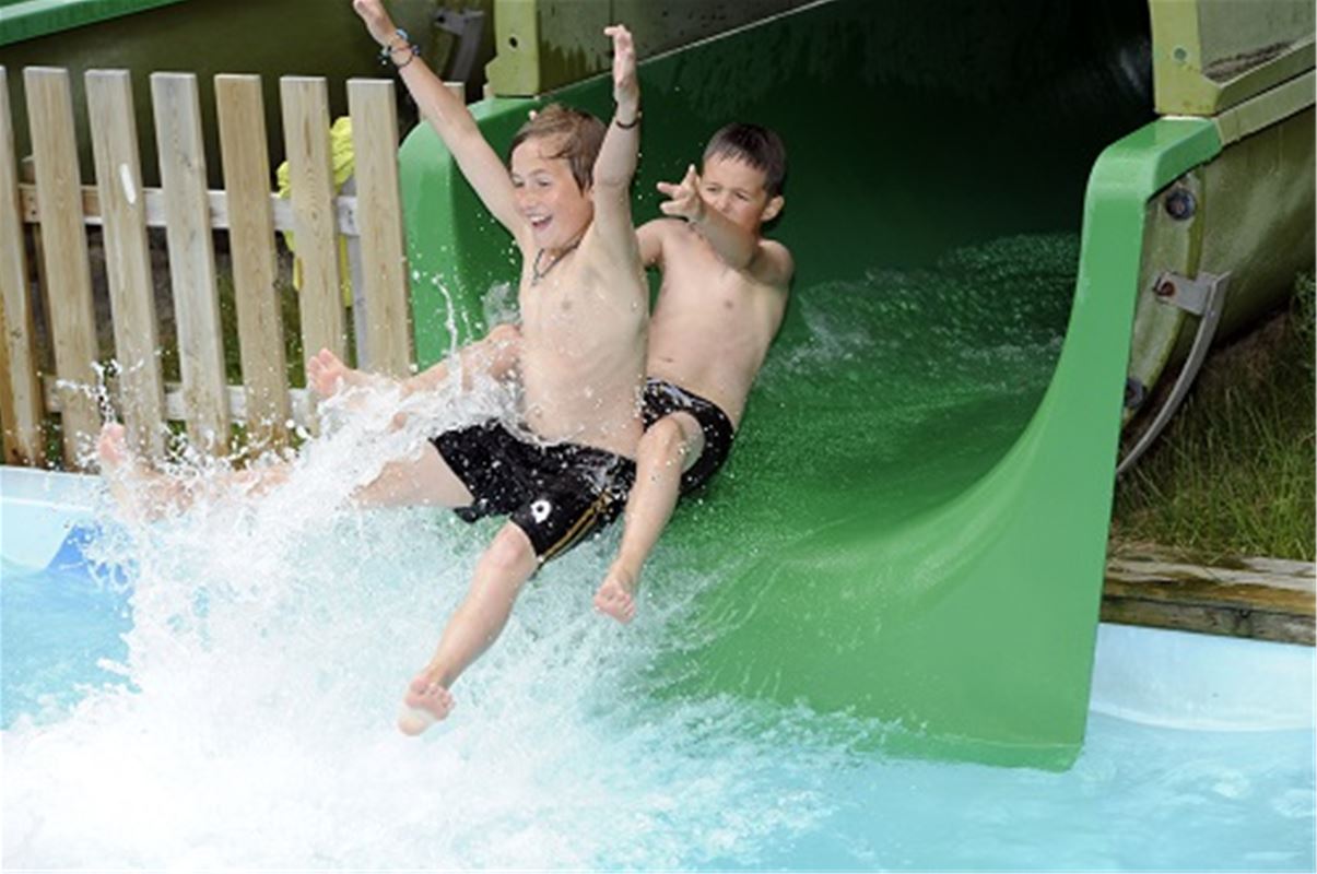 Två barn som åker vattenrutschbana