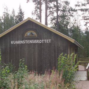 Brown wooden house with the text Kvarnstensbrottet.