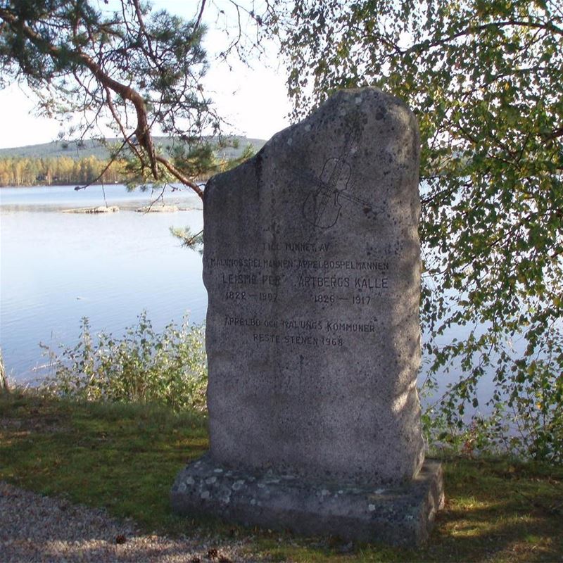 Memorial stone outside the church with lake behind.