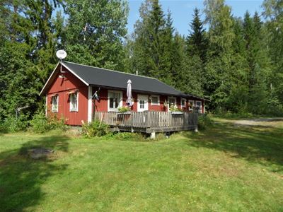 The cottage, from the lake, with the porch and a parasol.