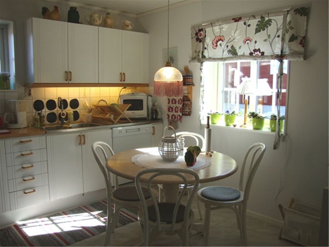 Kitchen with white cabinet doors, round table with four chairs. 
