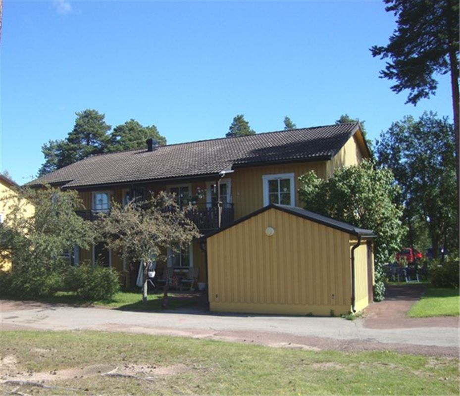 Yellow wooden house in two floors with a store house in front. 