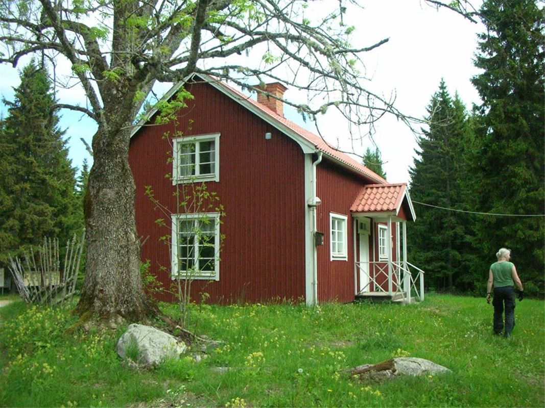Red cottage and a woman in the garden.