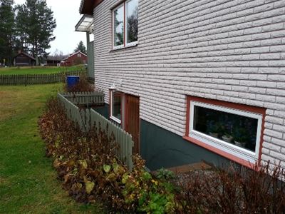 Gable in white mexican brick and a staircase down to a basement entrance.