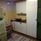 White kitchenette with stove, sink and a green fridge and freezer.