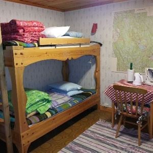 Bunk bed in pine and a small table with a chair next to it.