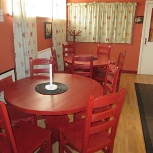 Dinnerplace with red round tables and chairs.