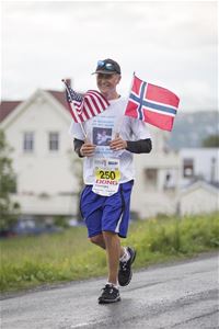 En mann løper med det norske og amerikanske flagget i hånda