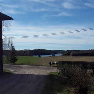 Utsikt från gården ner över åkrarna mot sjön Nävden.