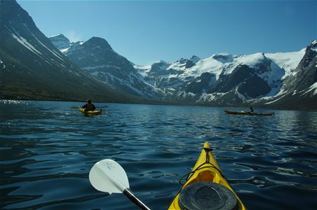 Kajakk inne i en fjord med høye fjelltopper rundt