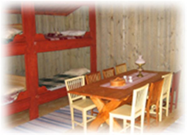 Dining furniture placed in front of two red painted bunkbeds.  