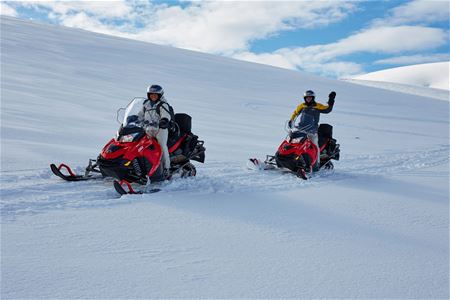 Guests driving snowmobile