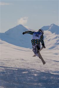 A skier does a high jump and a cool trick