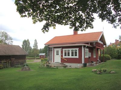A red cabin with a balcony.