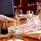 Set table in te restaurant with white napkins, glasses of wine and a carafe of water.