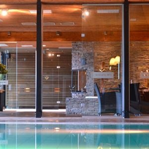 Indoor pool in a room with large windows.