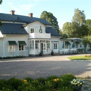 Foto: Wanbo Herrgård,  A large gray house.