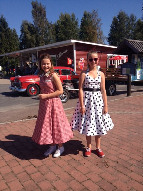 Två flickor i klänningar i 60-talsstil.