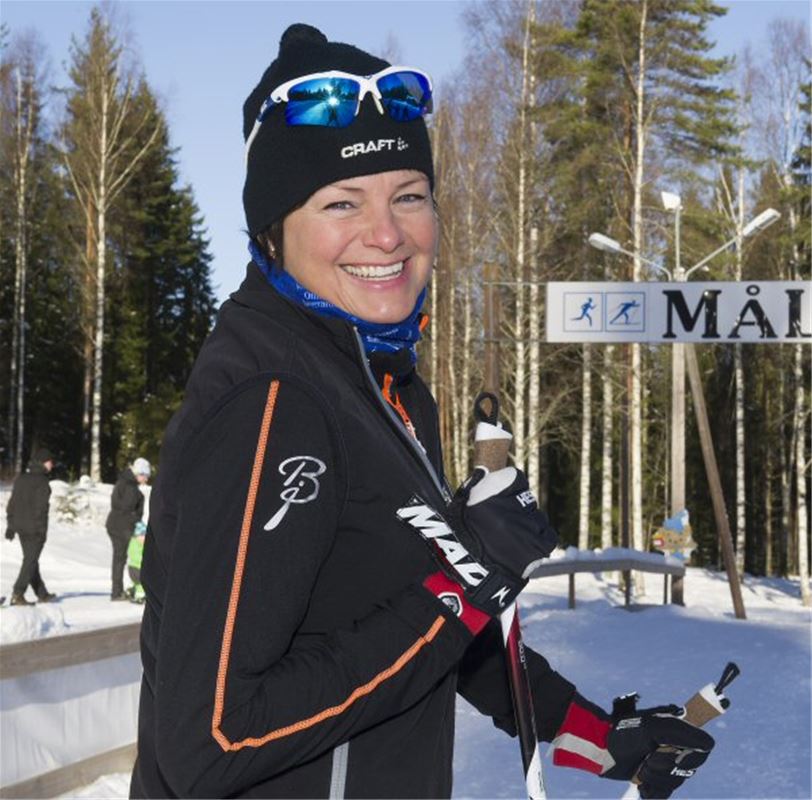 Woman on cross-country skis smiling.