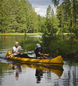 Två personer paddlar kanot.