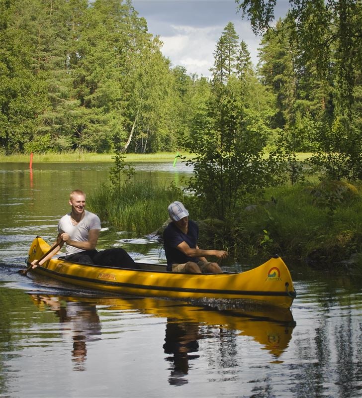 Två personer paddlar kanot.