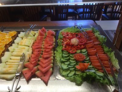 Ett buffébord med olika frukter och sallader.
