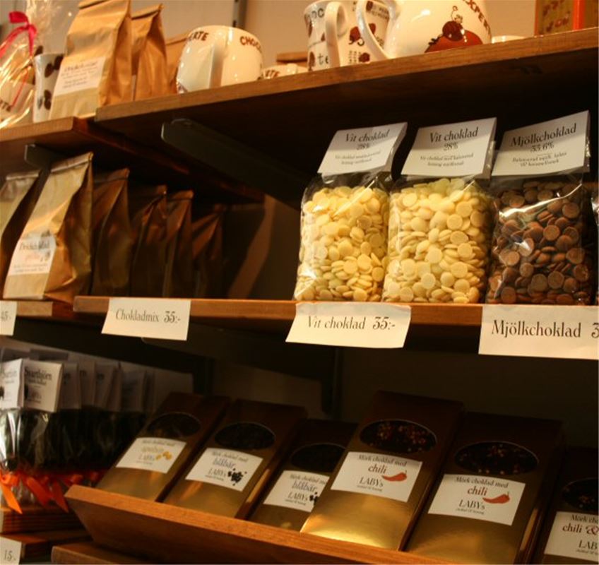 Shelves with different products, chocolate cookies bags with chocolate buttons.
